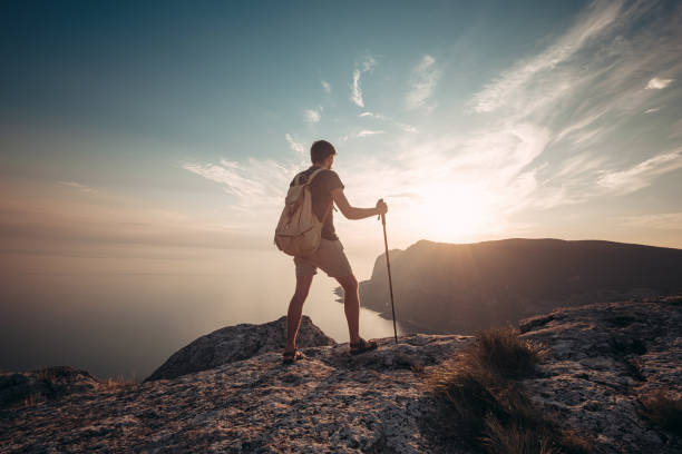 istock Man hiking at sunset mountains with heavy backpack 1234508238