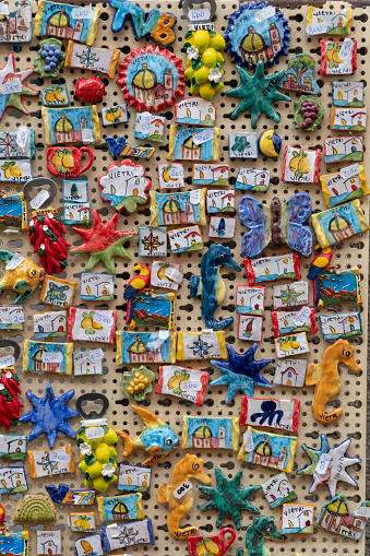 Vietri/Italy - 09.08.2017: Close up on many handcrafted ceramic refrigerator magnets in beautiful vivid colors and designs with price label at a store selling traditional souvenirs.