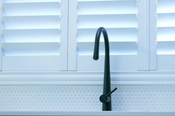 Plantation shutters and black kitchen faucet stock photo