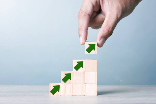 istock Wood block cubic stacking step up with Green Arrow Blue Tone. 1234585391