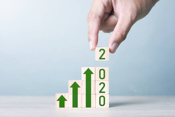 istock Wood block cubic stacking step up with Green Arrow and 2020. 1234585401