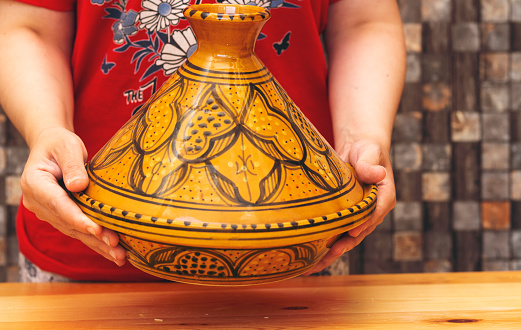 woman holding traditional morocco tajine ( means plate in english ) made of clay