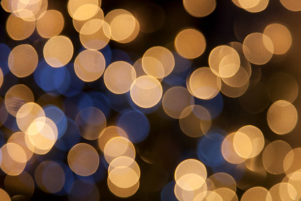 defocused golden light dots against black background stock photo