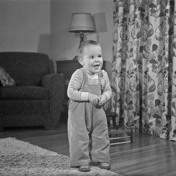 toddler standing in living room 1952, retro Toddler standing in living room. Iowa, USA 1952. Scanned film with grain. 1952 stock pictures, royalty-free photos & images