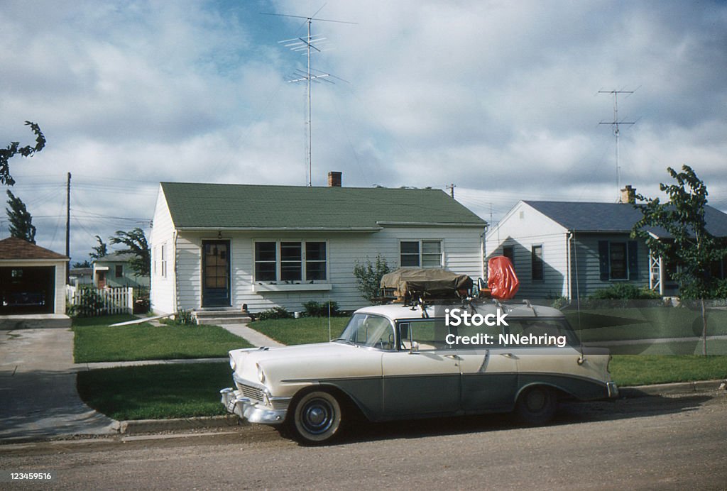 1956 Chevrolet parked in front of 50's home 1956 Chevrolet station wagon packed for vacation in front of new tract house with TV antenna. Symbols of the affluent post WWII society in USA. Waterloo, Iowa, 1957. Kodachrome scanned film with grain. 1950-1959 Stock Photo