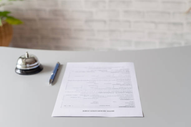 istock Hotel reservation form and silver vintage bell on reception desk with copy space. Hotel service, registration. Selective focus 1234601557