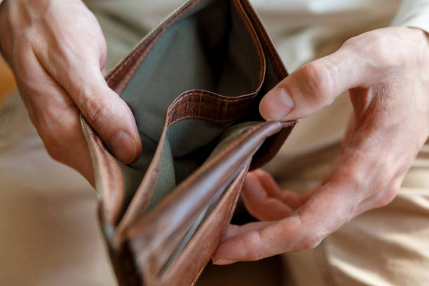 istock Empty wallet in the hands of a man on a plain background 1234614082