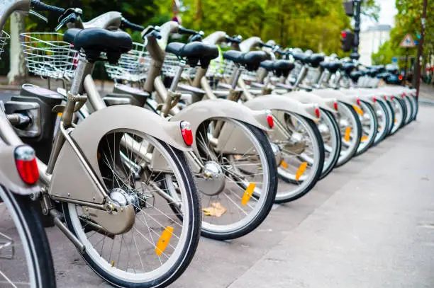 A fleet of shared bicycles neatly lined-up in a row at a docking station.