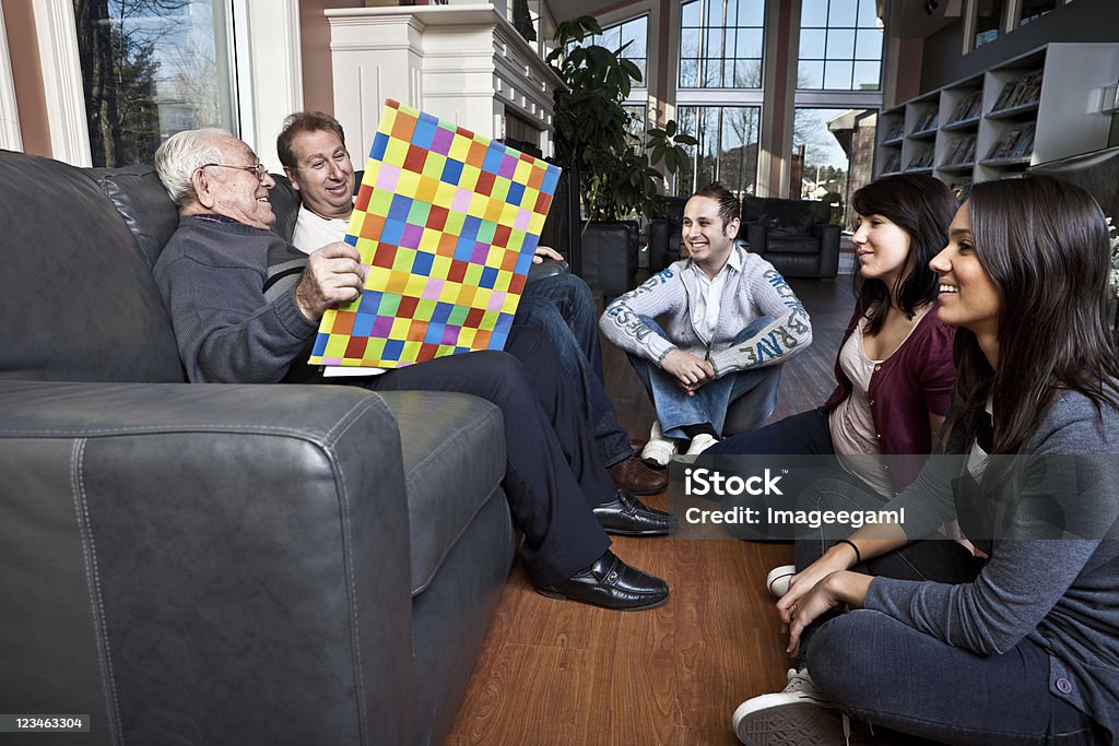 Three generations of a family sharing some quality time Story Time, gentleman holding the story book is 97 years old. 80-89 Years Stock Photo