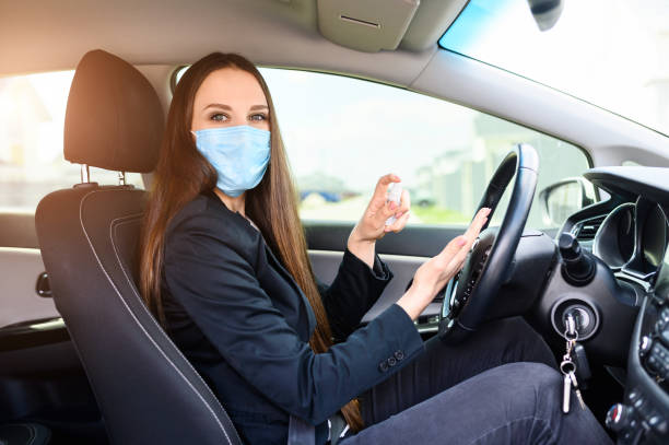 istock Young woman in protective mask is driving car 1234641448