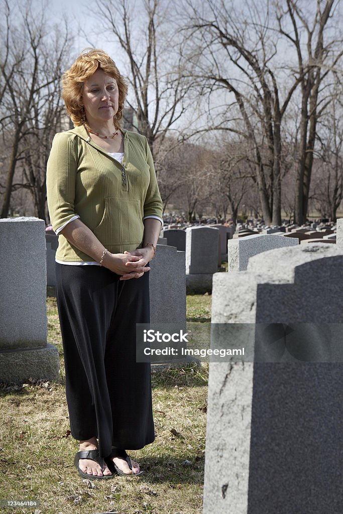 Apenadas mujer frente a cemetary bien a tombstone - Foto de stock de Adulto libre de derechos