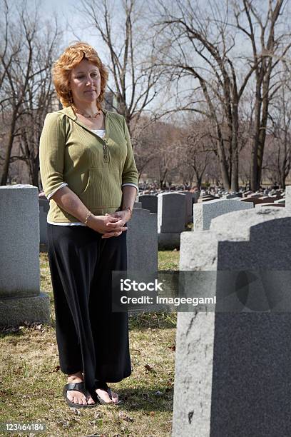 Apenadas Mujer Frente A Cemetary Bien A Tombstone Foto de stock y más banco de imágenes de Adulto - Adulto, Angustiado, Cementerio