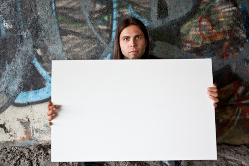 Homeless man holding a blank sign.