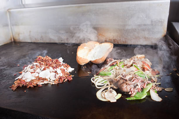 Woman working in a grilled fast food restaurant prepares a burger
