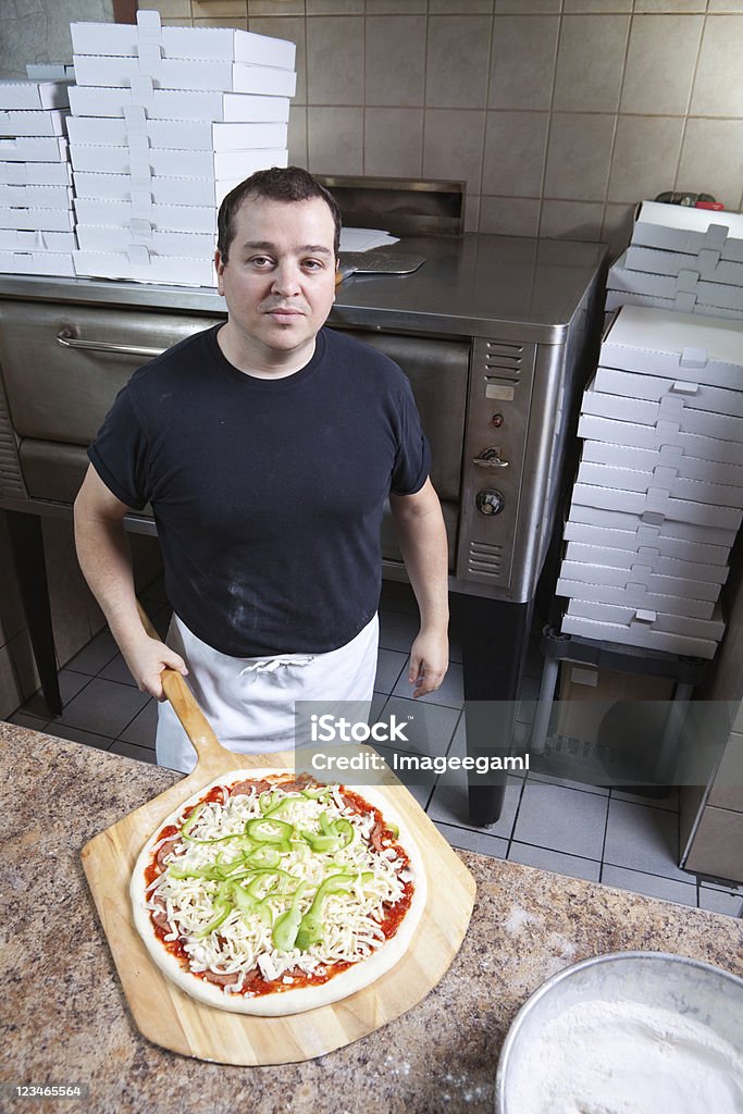 chef avec Pizza Tous habillés Tarte prêt pour un four - Photo de Boulanger libre de droits