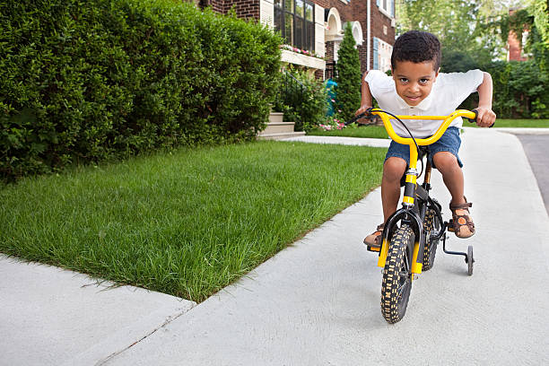 jeune garçon d'équitation un vélo - roue stabilisatrice photos et images de collection