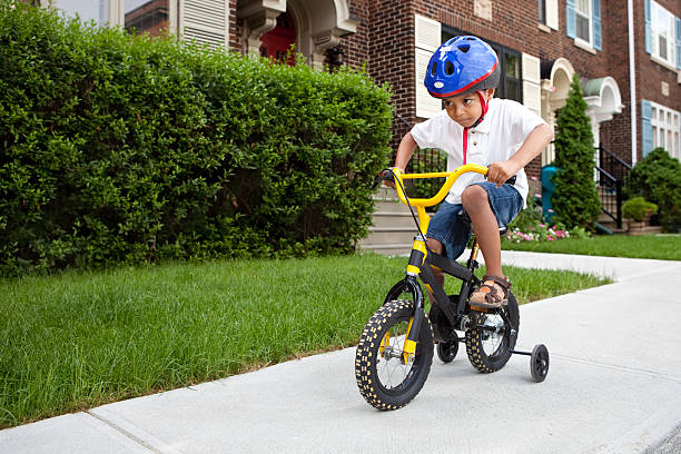 jeune garçon d'équitation un vélo - roue stabilisatrice photos et images de collection