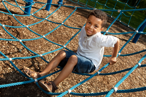 Young boy playing in a rope structure