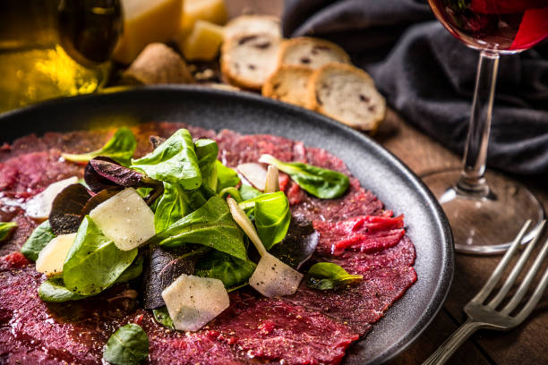 Beef carpaccio with arugula, parmesan cheese and red wine stock photo