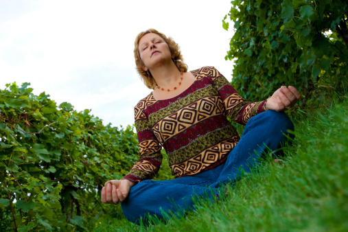 Woman meditating at a vineyard