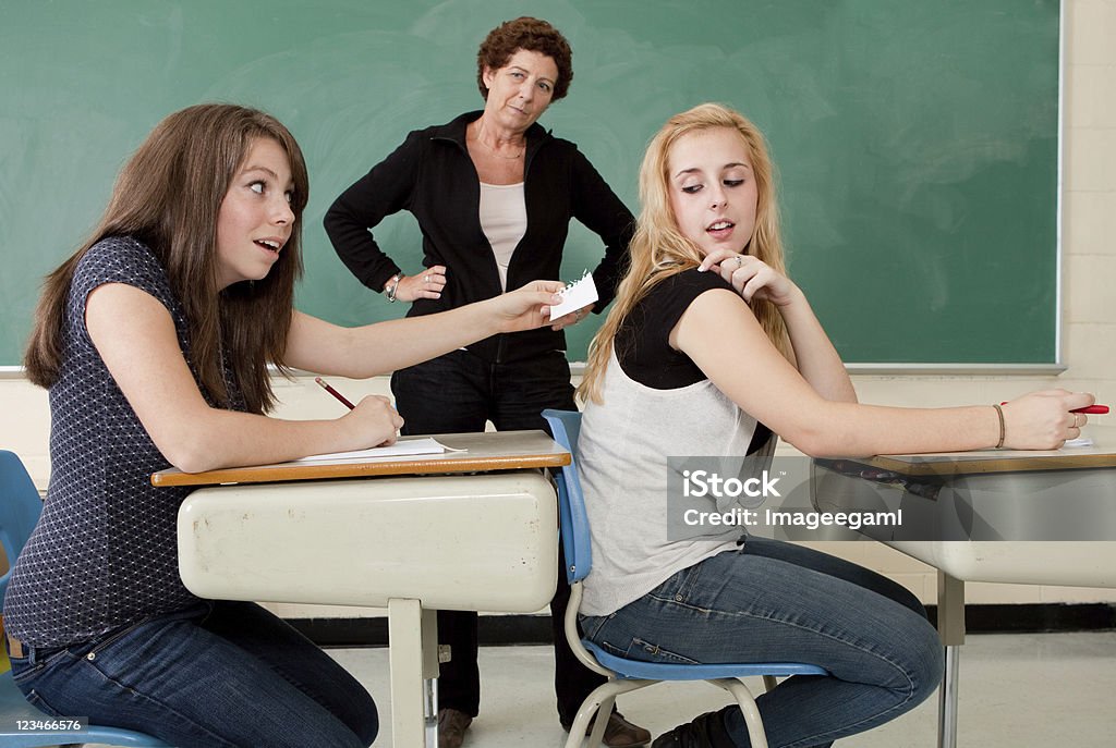 Caught cheating on an exam Teenage student caught passing a note to classmate Dishonesty Stock Photo