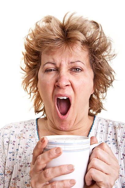 donna svegliarsi con una tazza di caffè - yawning women drink coffee cup foto e immagini stock