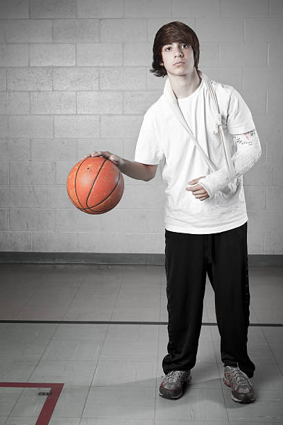 Teenager with broken arm playing basketball
