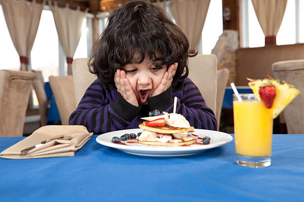 verzückt junge isst einen stapel pfannkuchen - eierkuchen speise stock-fotos und bilder