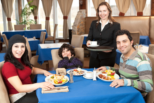 Happy family having breakfast in a restaurant