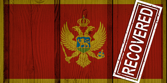 flag of Montenegro that survived or recovered from the infections of corona virus epidemic or coronavirus. Grunge flag with stamp Recovered