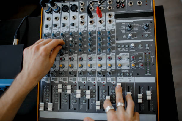 istock Hand on a mixer, operating the leader. Sound engineer working at mixing panel in the recording studio. Hands adjusting audio mixer. Close up concept. 1234728541