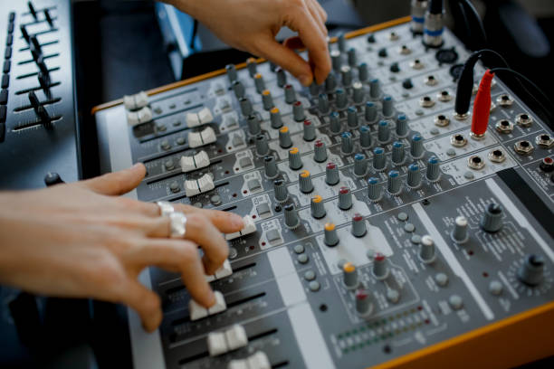istock Hand on a mixer, operating the leader. Sound engineer working at mixing panel in the recording studio. Hands adjusting audio mixer. Close up concept. 1234728545
