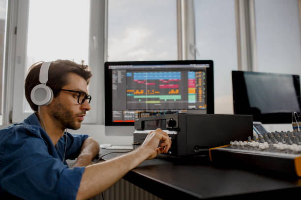 Male music arranger works with sound amplifier he is composing song on midi piano and audio equipment in digital recording studio. DJ in broadcasting studio. music, technology and equipment concept arreglista de música masculina trabaja con amplificador de sonido que está componiendo canción en piano midi y equipos de audio en el estudio de grabación digital. dj en estudio de radiodifusión. concepto de música, tecnología y equipos.