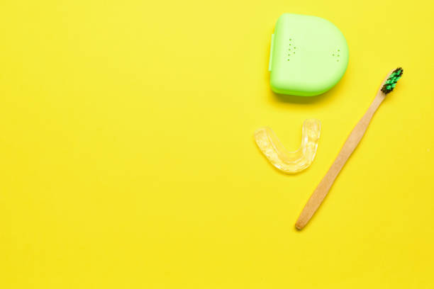 ecological toothbrush and dental aligner with its box on a yellow background - human teeth defending dental equipment brushing imagens e fotografias de stock
