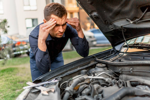 istock Car breakdown concept. The car will not start. The young man is trying to fix everything himself. They cannot fix the car on their own. Insurance must cover all costs. 1234748106