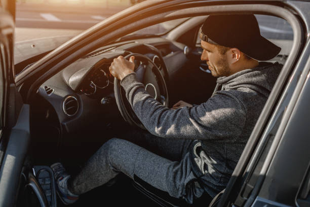 istock First car! A young man in a tracksuit sits in his car. 1234751897