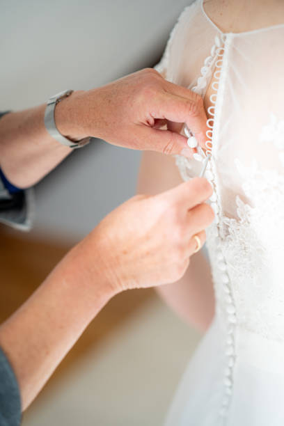 istock Mother hands buttoning wedding dress 1234781628