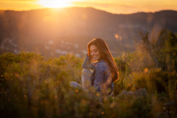 happy brunette spanish young woman in the nature at sunset
