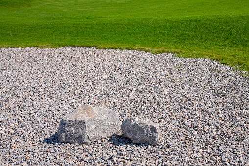 Landscaping, stones on gravel and lawn