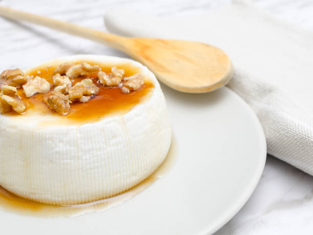 istock Fresh cheese with honey next to wooden spoon. 1234837771
