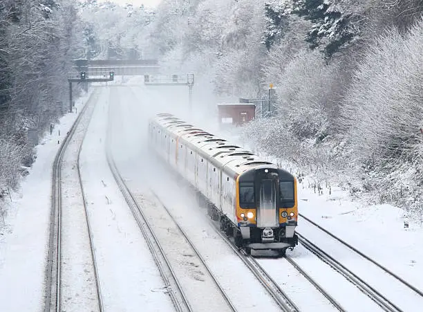 Photo of Train transporting commuters in winter snow and ice to London