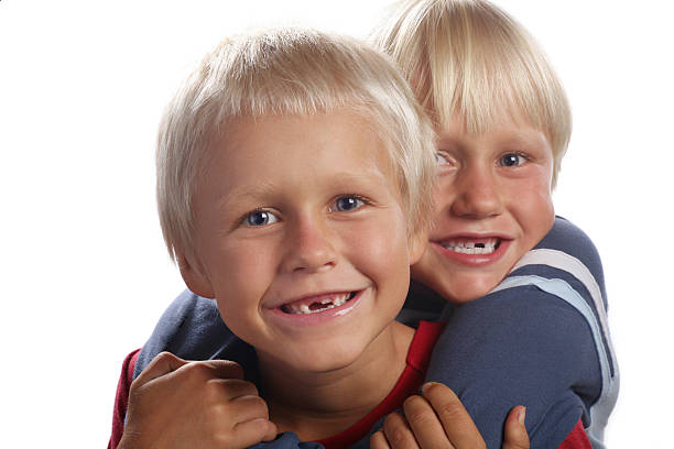 dois rapazes com falta de dentes - embracing smiling gap children only - fotografias e filmes do acervo