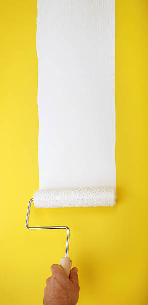 istock white paint roller on yellow wall XXL 123493288