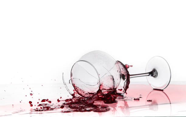 copa de vino rota sobre una mesa acolchada sobre fondo blanco - glass broken spilling drink fotografías e imágenes de stock