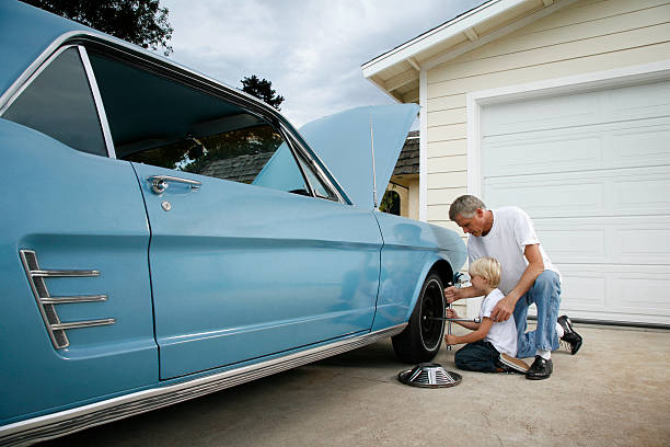 padre e hijo cambiando una rueda - coche doméstico fotografías e imágenes de stock