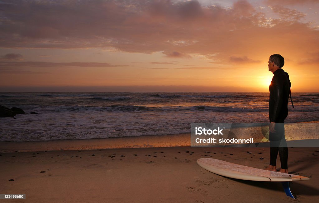 Surfisti al tramonto guardando fuori - Foto stock royalty-free di 1950-1959