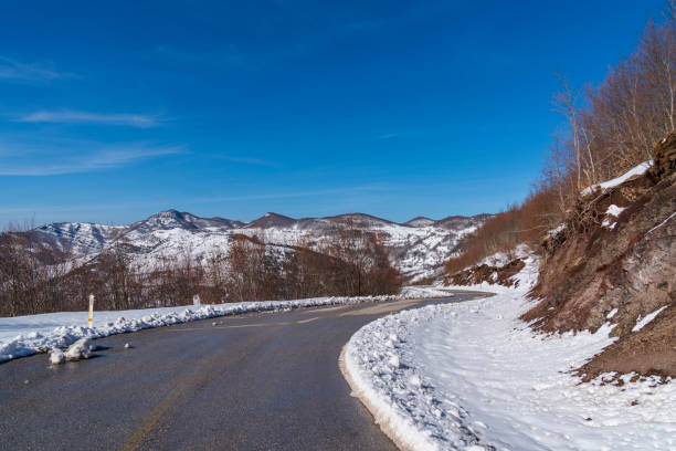 Snowy mountain road in sunny weather, mountain summit