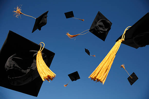 la remise des diplômes jettent casquettes dans l'air - blue fin photos et images de collection