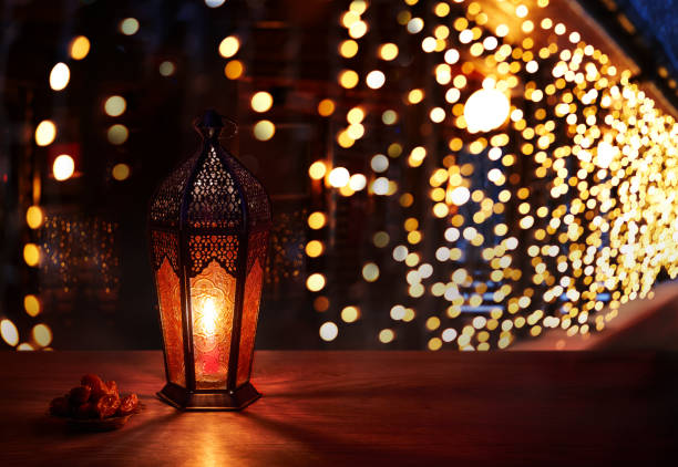 istock Ramadan lantern on the table. Dark background with light and bokehs. Beautiful Greeting Card with copy space for Ramadan and Muslim Holidays. An illuminated Arabic lamp. Mixed media. 1234973164