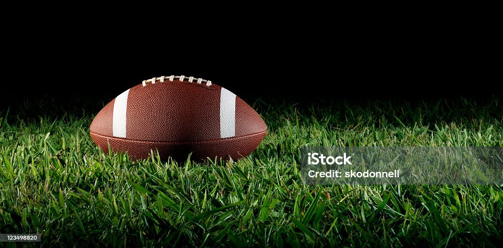 Football sur de l'herbe - Photo de Ballon de football américain libre de droits